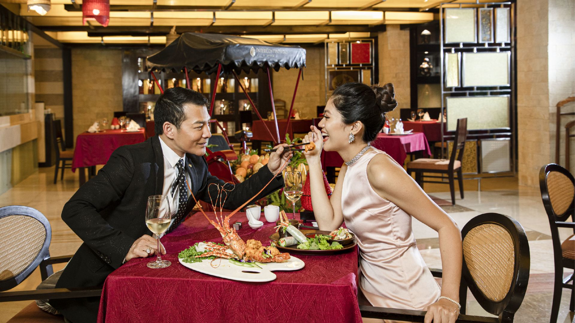 A Man And Woman Eating At A Restaurant